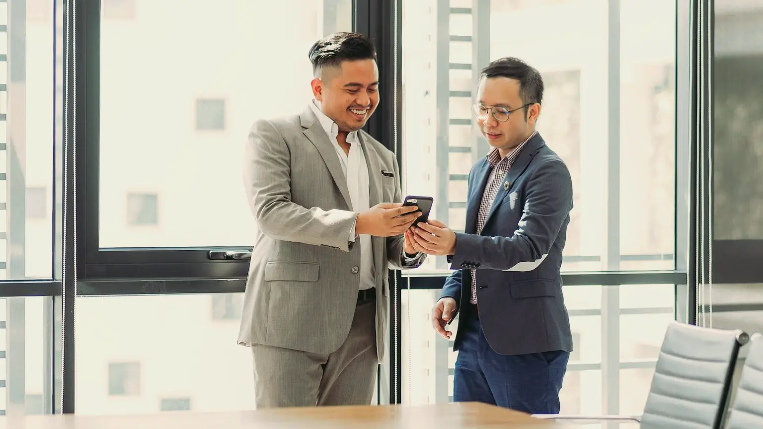 two men shaking hands in a conference room